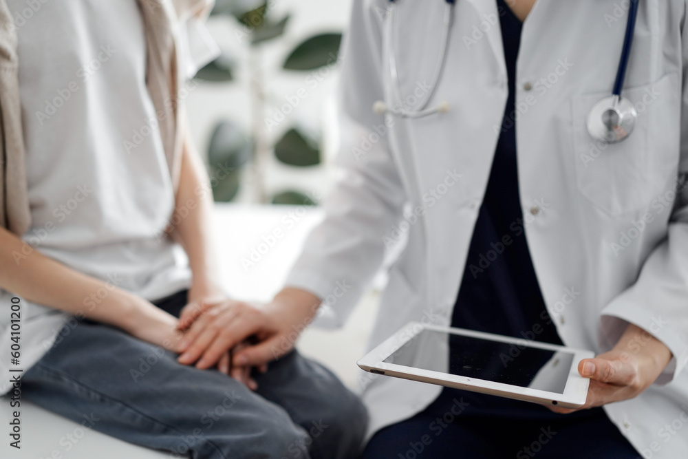 Doctor and child patient. The physician is holding tablet computer and reassuring a boy. The concept of ideal health in medicine.