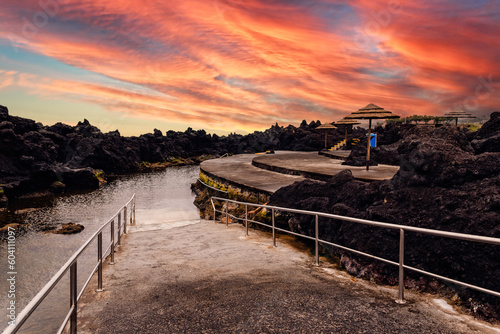 Natural pools at Biscoitos during a dramatic sunset in the coast of Terceira Island, Azores, Portugal photo