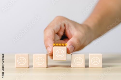 Emotional face symbols on wooden blocks Service ratings, ratings, customer reviews, satisfaction, evaluations, experience, and quality product marketing feedback.	
