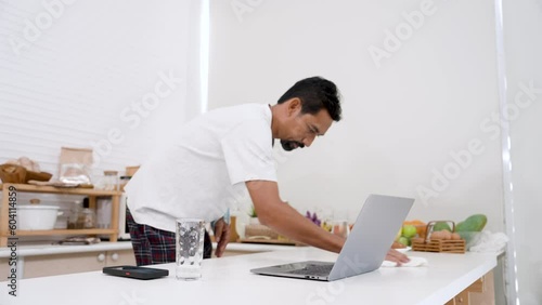 Asian man unaccustomed using one arm, because an accident, arm needs be rehabilitated, using a cloth absorb water at table because uses one hand print, causing it be accidentally scattered by water.