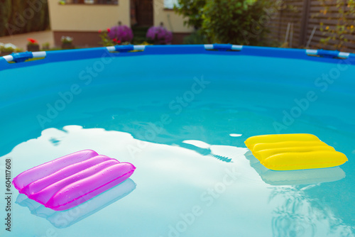 Two inflatable pillows lie on the surface of the water in the pool