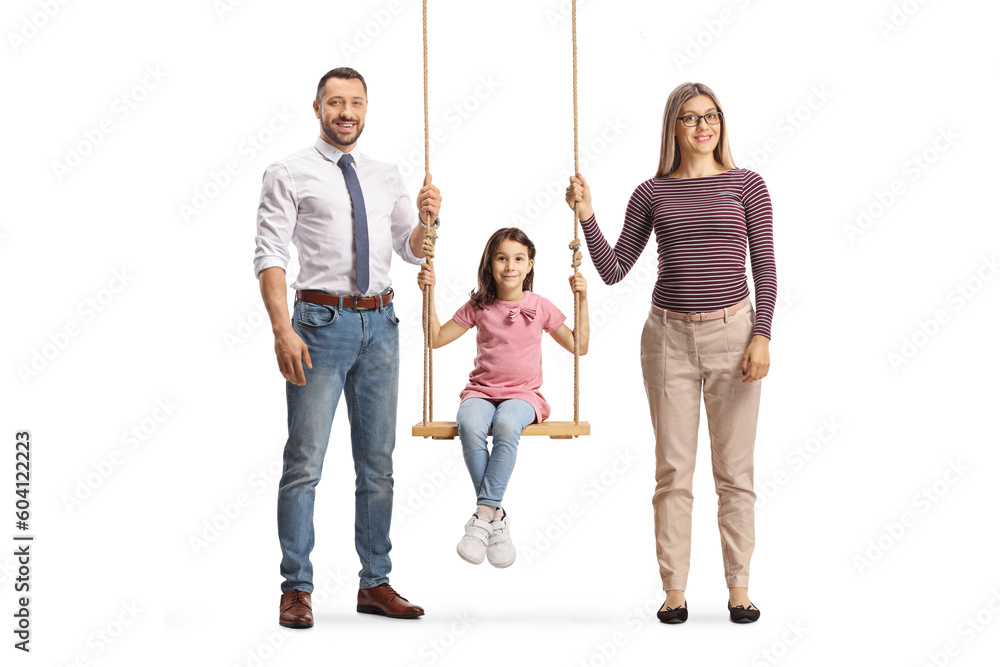 Fototapeta premium Full length portrait of a man and woman standing next to girl on a wooden swing