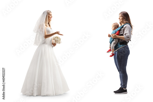 Full length profile shot of a bride talking to a mother with a baby