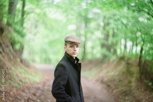 concept photo of a young man in a black coat and cap posing outdoors