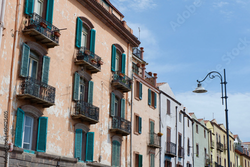 Shabby facades of different pastel colours on the street of Bosa, Sardinia, Italy © Yana Demenko
