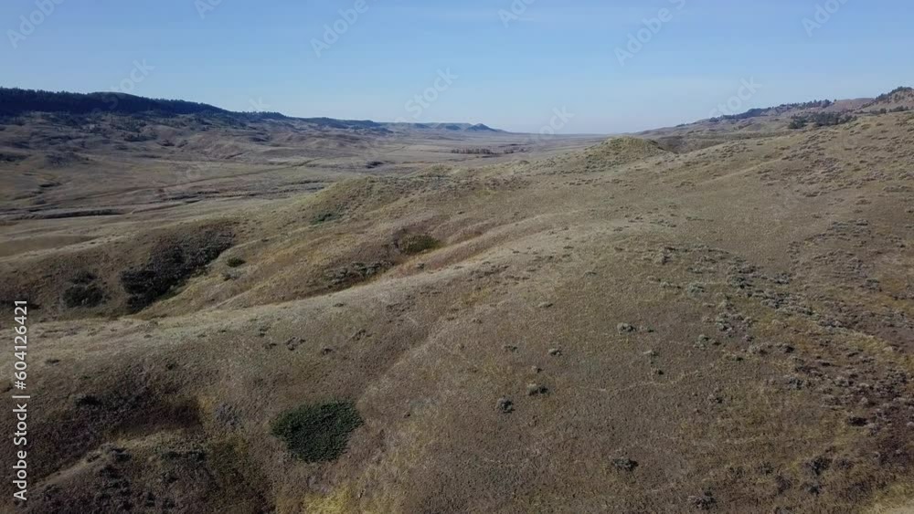 Drone flying over folds of prairie valley and hills Drone flying over folds of prairie valley and hills