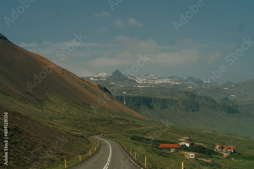 road through green mountains in iceland