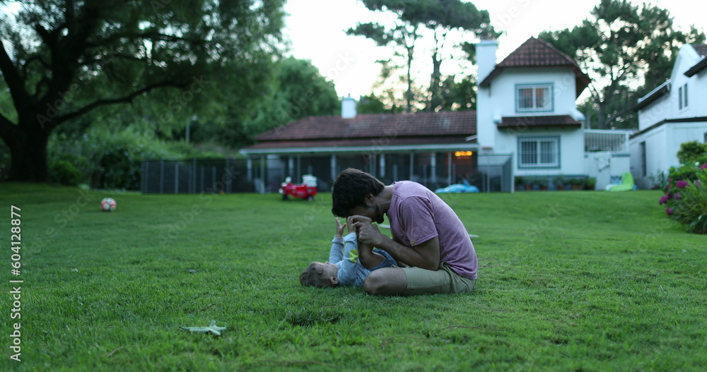 Fototapeta premium Father bonding with baby infant son in outdoor home garden