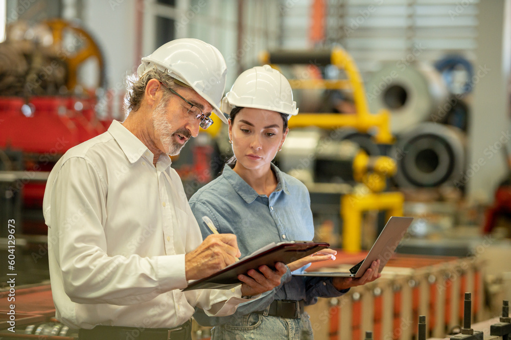 Two engineer technician assistant checker inspect checking walk heavy machine construction installation in factory . Boss and secretary talking and check inventory in clipboard maintenance factory Two engineer technician assistant checker inspect checking walk heavy machine construction installation in factory . Boss and secretary talking and check inventory in clipboard maintenance factory