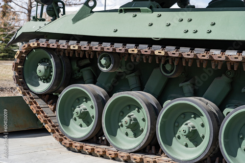 Tank tracks parked on concrete with green camouflage colour.