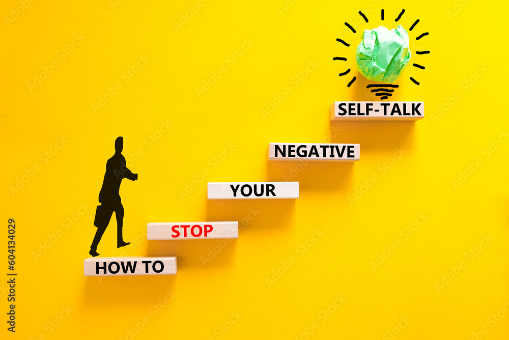 Stop negative self-talk symbol. Concept words How to stop your negative self-talk on wooden block. Psychologist icon. Beautiful yellow background. Psychological negative self-talk concept. Copy space - obrazy, fototapety, plakaty 
