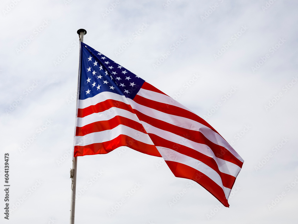 Naklejka premium Flag of the United States against cloudy sky