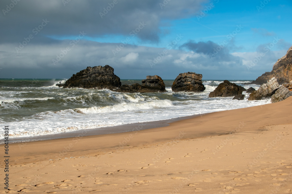 Empty wild sandy beach, Atlantic Ocean seascape, sea waves, beautiful cloudscape, dramatic landscape, travel content, Lisbon, Portugal