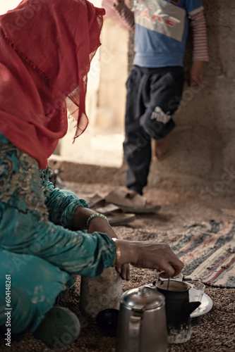 Valokuva Bedouin woman cooking tea on the fire in Bedouin village, Egypt