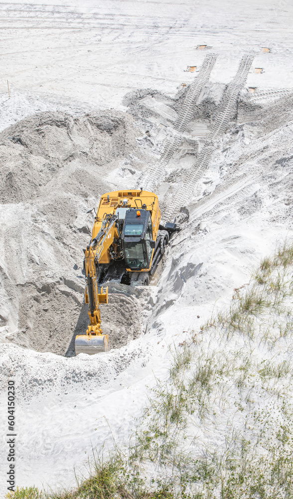 Backhoe digging in the beach sand Backhoe digging in the beach sand