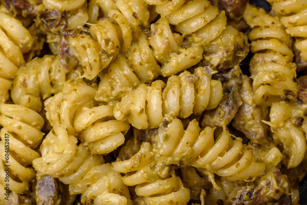 Delicious fusilli pasta with green pesto sauce, with salt and spices Delicious fusilli pasta with green pesto sauce, with salt and spices