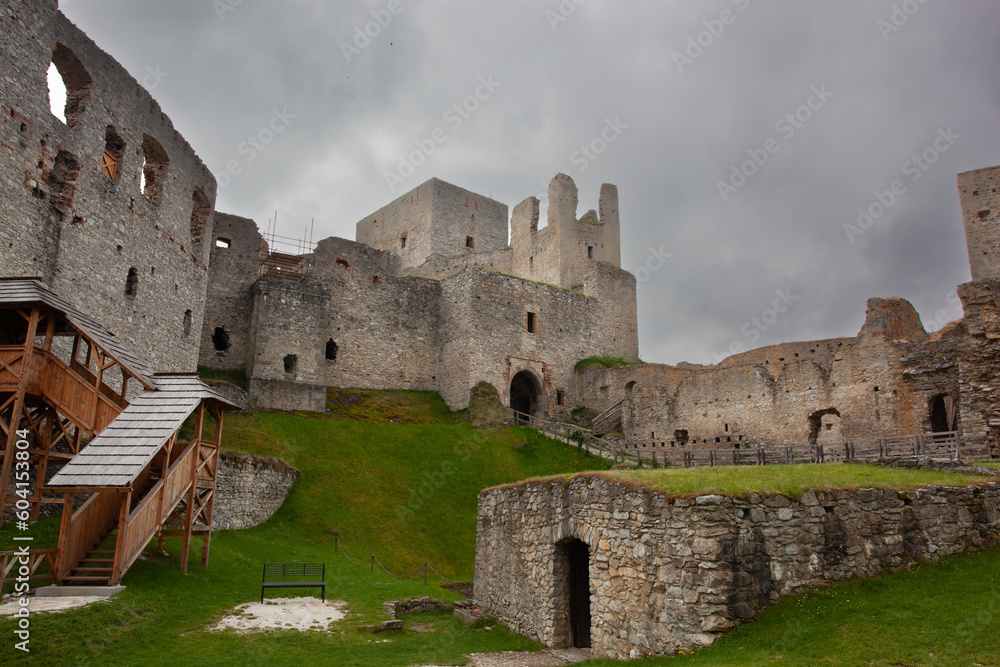 View of a fortified castle in ruins on an overcast day. Low angle shot of the central buildings of the fortified castle with the white stone keep in the centre.