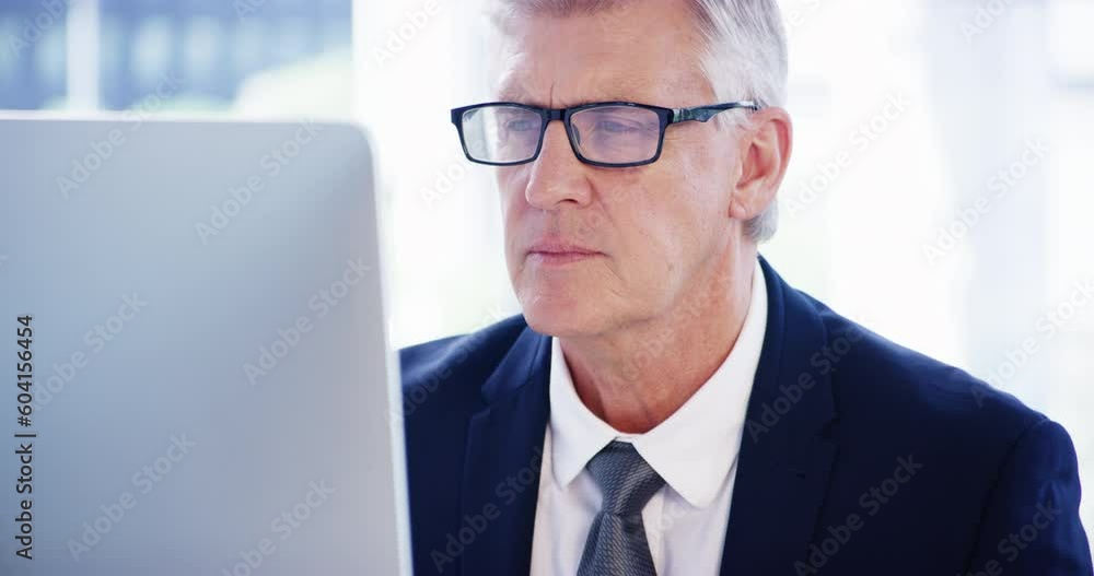 Computer, reading a senior business man at work in his office for management of a corporate company. Desktop, glasses and planning with a mature male manager or CEO working on a report or review Computer, reading a senior business man at work in his office for management of a corporate company. Desktop, glasses and planning with a mature male manager or CEO working on a report or review