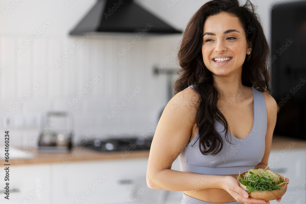 Beautiful smiling woman holding bowl with fresh micro green Beautiful smiling woman holding bowl with fresh micro green