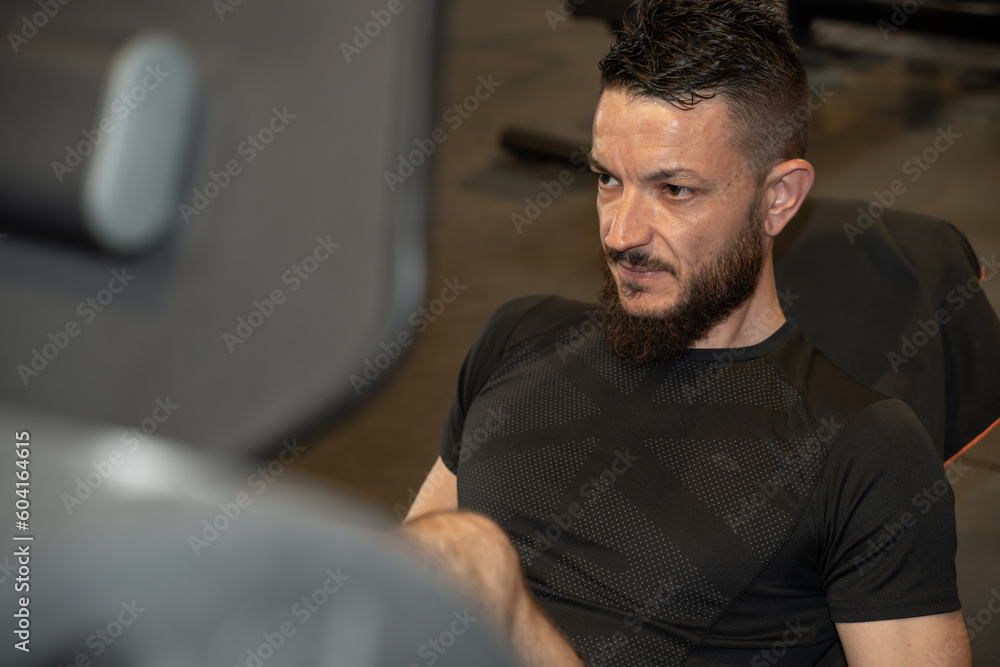 Jeune homme faisant du sport dans une salle de musculation Jeune homme faisant du sport dans une salle de musculation