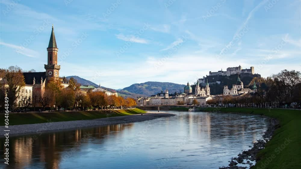 Autumn daytime timelapse of Salzburg, Austria featuring a beautiful riverscape with Hohensalzburg Fortress, cirrus clouds, old city, and river in the foreground. Autumn daytime timelapse of Salzburg, Austria featuring a beautiful riverscape with Hohensalzburg Fortress, cirrus clouds, old city, and river in the foreground.