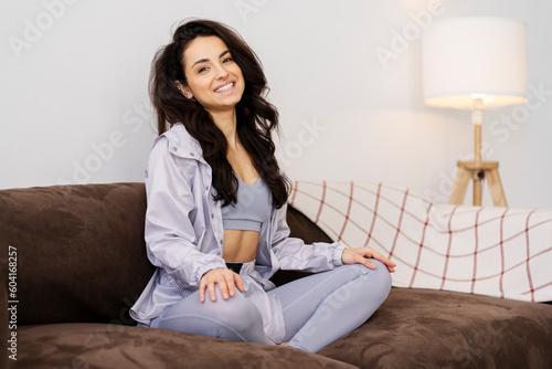 Beautiful happy latin woman wearing stylish pyjamas sitting in lotus position