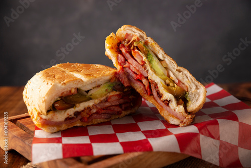 Mexican Torta. Sandwich made with common bread in Mexico, it can be telera, bolillo or bagette, split in half and filled with various ingredients, in this case spicy pork leg with Oaxaca cheese. photo