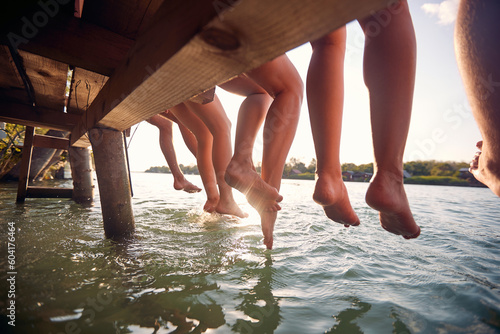 Canvas Print friends sitting on the dock and  enjoying together at vacation dangling legs in