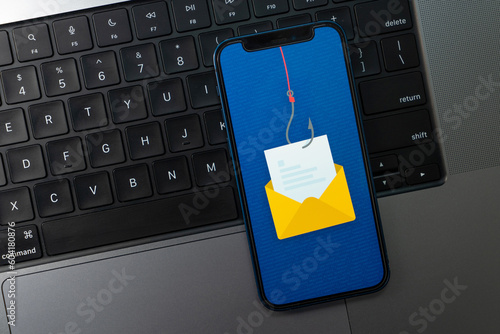 Email Phishing Concept on a Smartphone Screen over a Laptop Keyboard photo