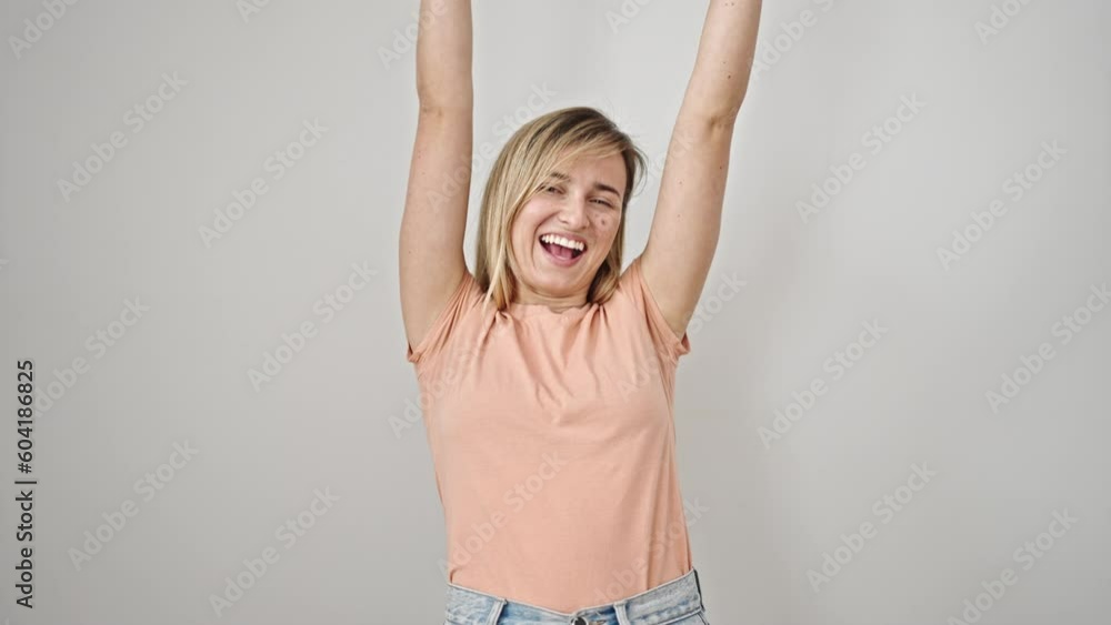 Young blonde woman smiling confident standing with winner expression over isolated white background Young blonde woman smiling confident standing with winner expression over isolated white background