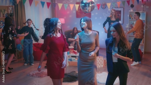 At the party, teenagers dance in separate groups. A group of three girls are dancing separately, the girls are talking, smiling. Dance of three girlfriends close up. Party, birthday, celebration.