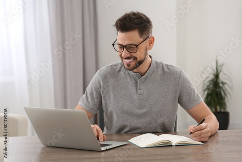 Man studying on laptop at home. Online translation course