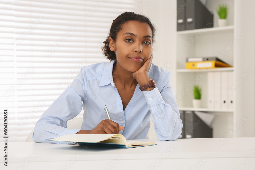 African American intern working at white table in office African American intern working at white table in office