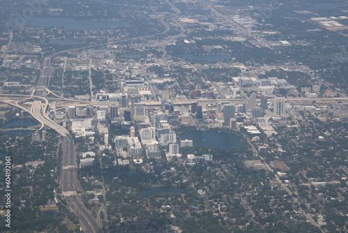 A bustling cityscape surrounded by lush greenery, Orlando, Florida aerial view showcases theme parks, lakes, vibrant neighborhoods, and iconic landmarks.
