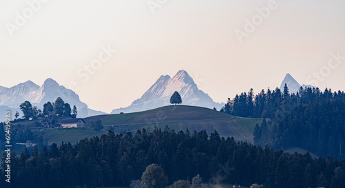 Schreckhorn, Wetterhorn, Finsteraarhorn and Eiger mountains view from green rolling hills, Sumiswald, Emmental, Bern, Switzerland