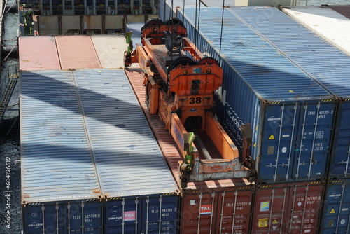 Bilde på lerret Container attached to spreader of gantry cranes operated by stevedores are loaded on the ship