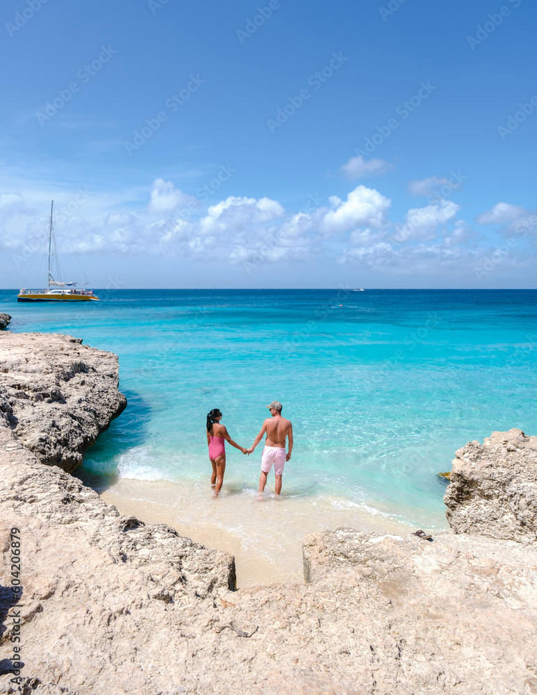 Tres Trapi Steps Triple Steps Beach, Aruba completely empty, Popular beach among locals and tourists for diving and snorkeling, couple man and woman in a crystal clear ocean in the Caribbean 
