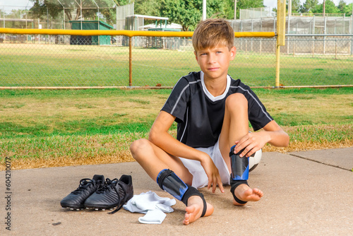 Young male soccer player getting dressed before a game photo