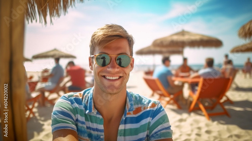 young adult man on the beach, sandy beach on summer vacation, tourists in swimwear on background, sea and water, tourism, fictional place © wetzkaz