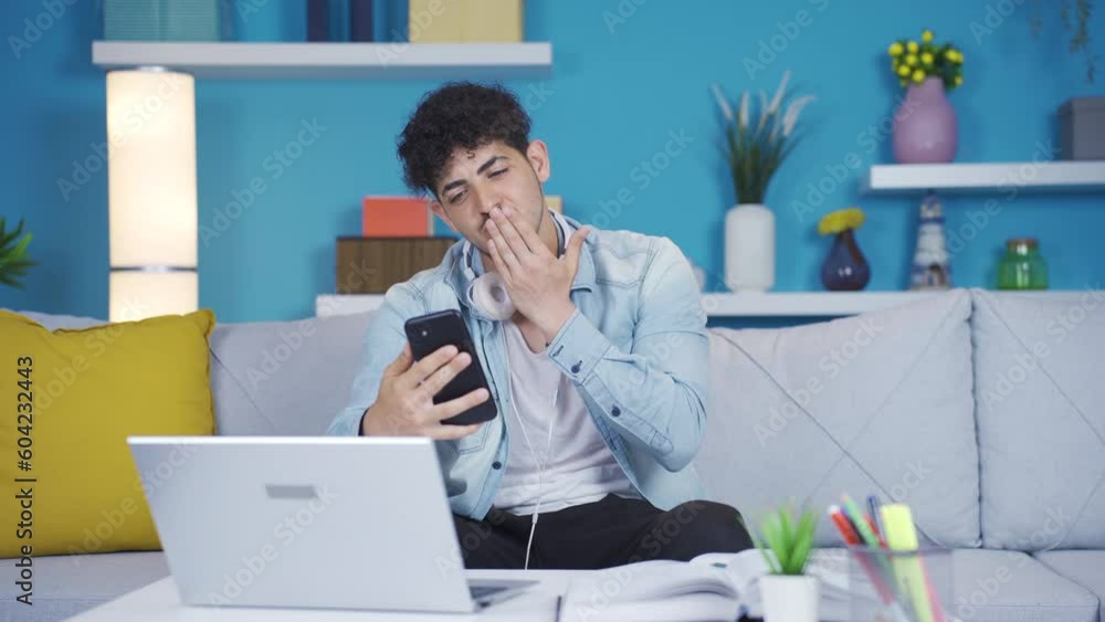 Young student video chatting with his friend on the phone. Young student video chatting with his friend on the phone.