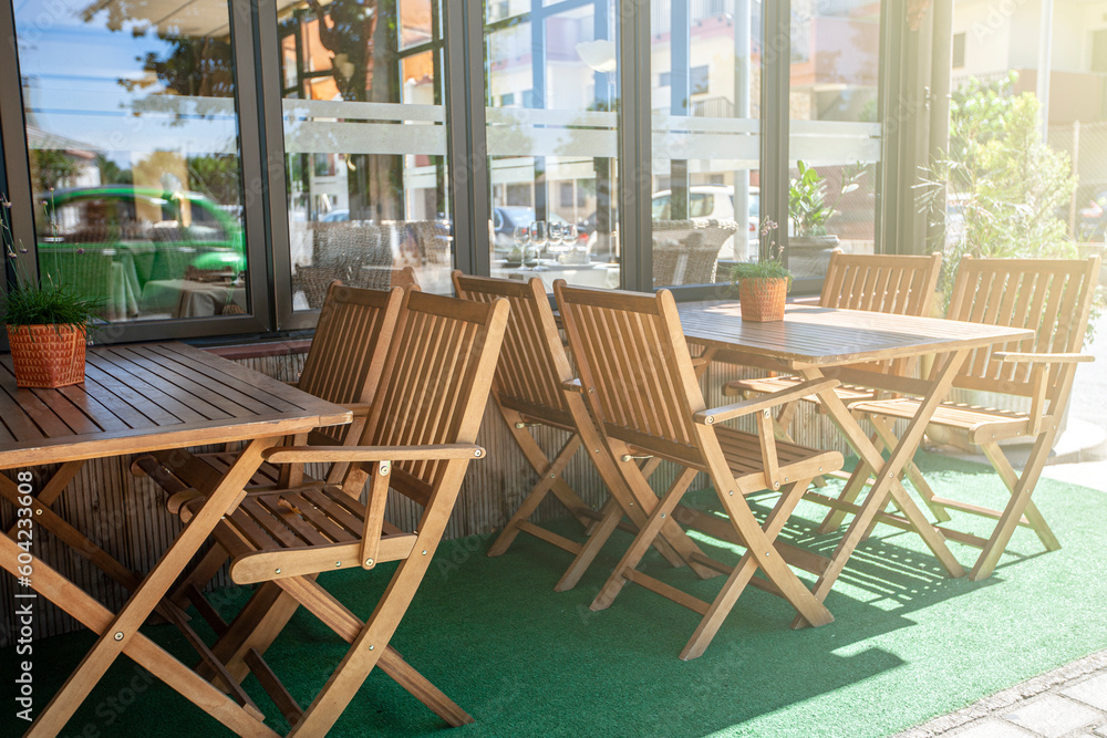 Outdoor cafe with wooden chairs in soft sunlight