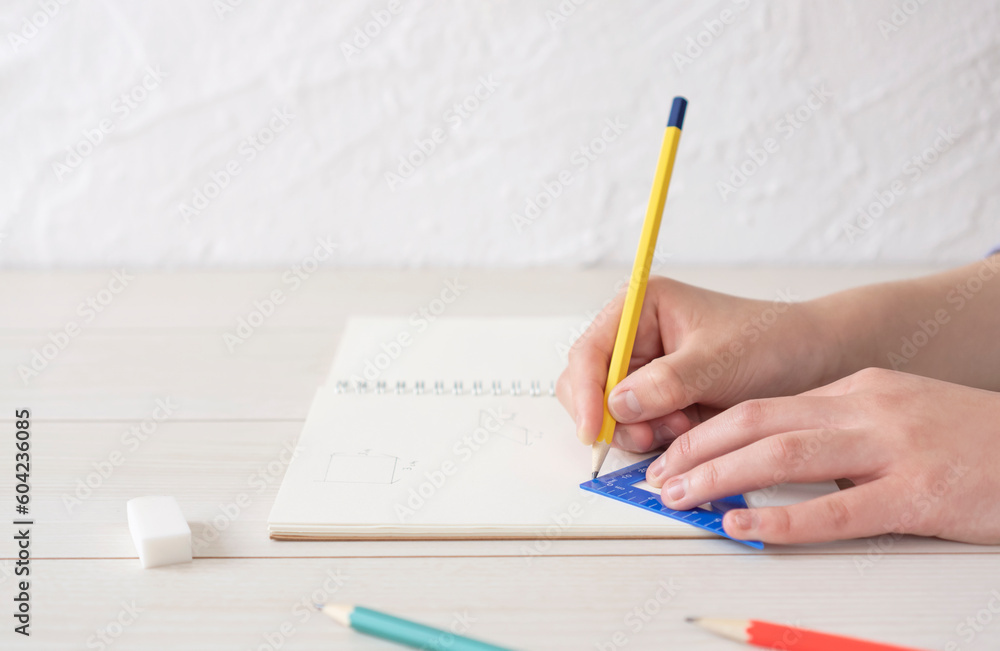 A child writing shapes in notebook. A person who solves math problems. ノートに図形を書く子供。算数の問題を解く人 A child writing shapes in notebook. A person who solves math problems. ノートに図形を書く子供。算数の問題を解く人