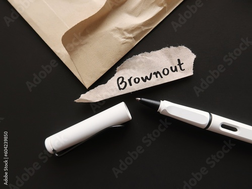 Torn office envelope and pen writing word BROWNOUT, Employees feel overworked, demotivated and disengaged – which is essentially the stage before burnout