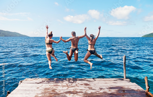 Εκτύπωση καμβά Back, group and women on a pier, jump and beach with vacation, summer getaway or relax