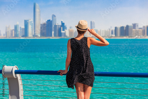 Tourist woman in Abu Dhabi, UAE. Sea, beach and skyscrapers background