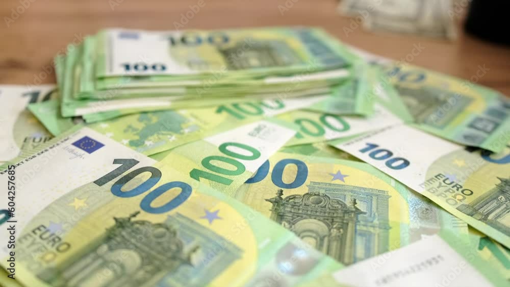 Lot of 100 euro bills lies on wooden table. Many paper money cash. Financial success and abundance, highlighting the idea of wealth and the power of money. Lot of 100 euro bills lies on wooden table. Many paper money cash. Financial success and abundance, highlighting the idea of wealth and the power of money.