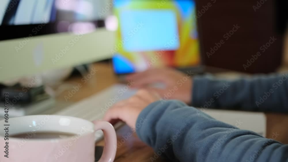 Girl dressed in gray jacket working from home, sits at desktop with computer. Woman with glasses typing on the keyboard. Work at home. Girl dressed in gray jacket working from home, sits at desktop with computer. Woman with glasses typing on the keyboard. Work at home.
