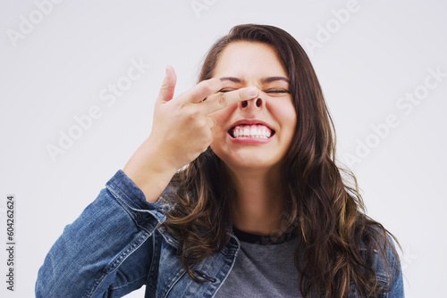 Smile, funny face and nose with a crazy woman in studio on a white background for carefree humor. Comic, comedy and showing nostrils with a weird young female person feeling playful while joking photo