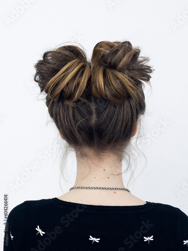Photo of a stylish hairstyle on a girl's head from behind. Image for your creative decoration or design.