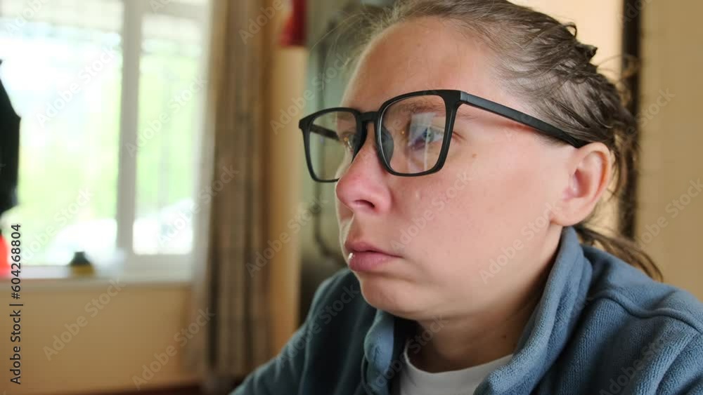 Hardworking young woman works in an office in glasses which reflects a computer monitor. Freelancer girl of the face of tired in office at home difficulty maintaining concentration and productivity w Hardworking young woman works in an office in glasses which reflects a computer monitor. Freelancer girl of the face of tired in office at home difficulty maintaining concentration and productivity w